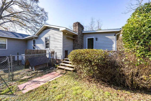 a backyard of a house with table and chairs