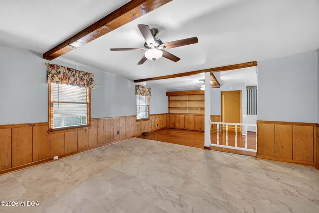 en empty room with windows and ceiling fan