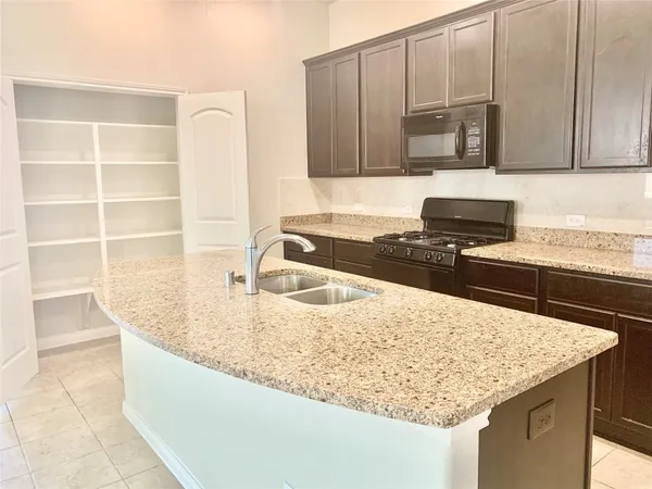 a view of a kitchen with stainless steel appliances kitchen island granite countertop a refrigerator and a stove