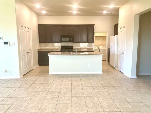 a view of a kitchen with wooden floor and a refrigerator