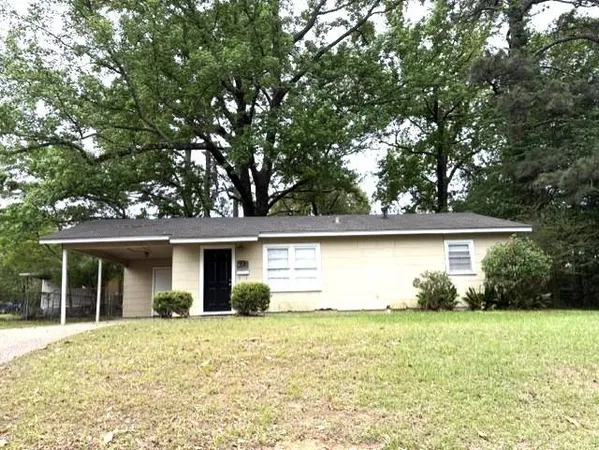 a front view of house with yard and trees around