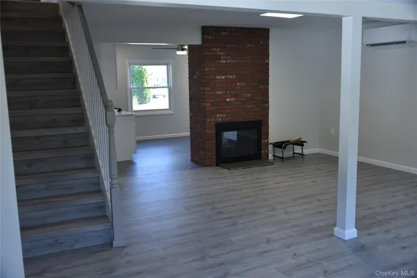 a view of a livingroom with wooden floor and a fireplace