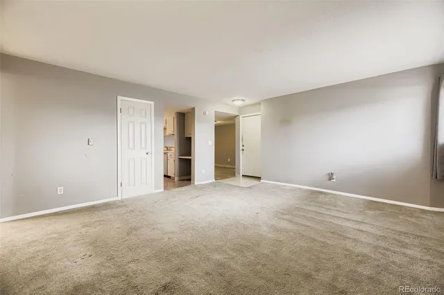 a view of an empty room with closet and bathroom