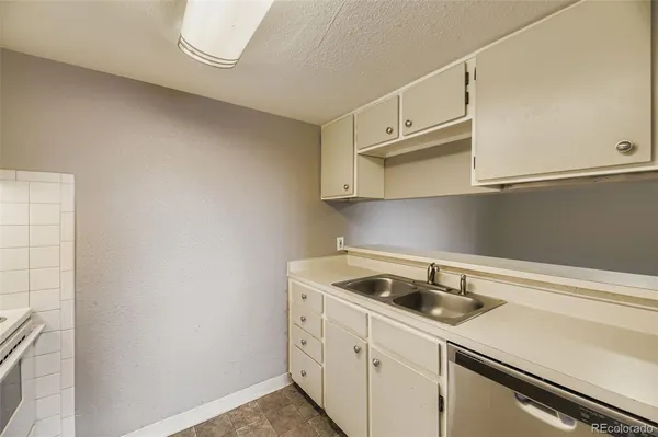 a kitchen with white cabinets a sink and dishwasher