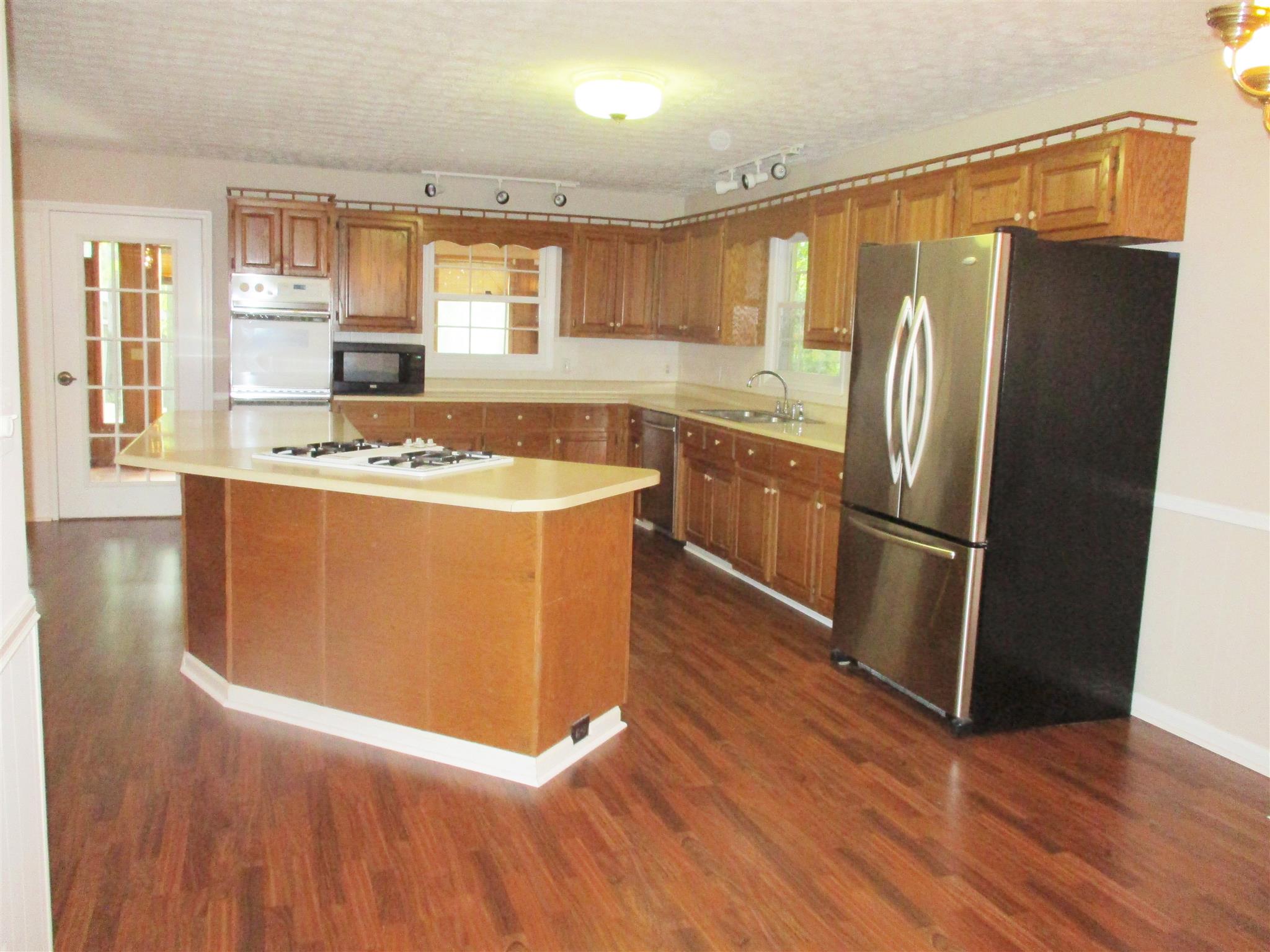 1073 West Point Road Lawrenceburg, TN 38464 - Photo 17 of 24 a kitchen with stainless steel appliances granite countertop a refrigerator a sink and a stove