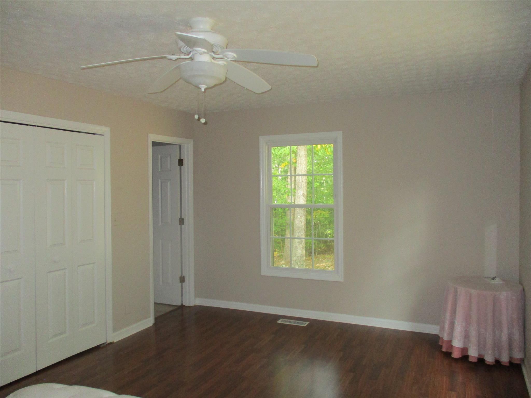 1073 West Point Road Lawrenceburg, TN 38464 - Photo 18 of 24 an empty room with wooden floor fan and windows