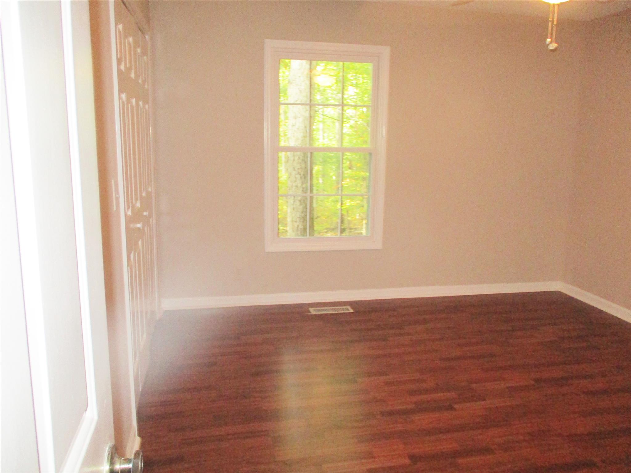 1073 West Point Road Lawrenceburg, TN 38464 - Photo 24 of 24 a view of an empty room with wooden floor and a window