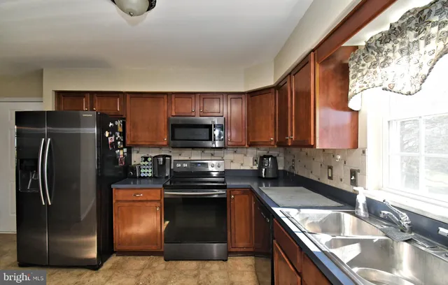 a kitchen with granite countertop a sink stove and refrigerator