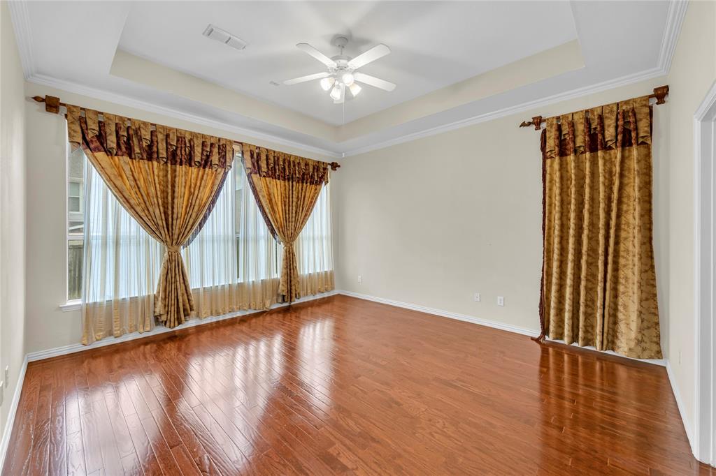 3920 Autumn Lane Bedford, TX 76021 - Photo 20 of 36 Spacious room featuring wood-finish flooring, a tray ceiling, and a ceiling fan