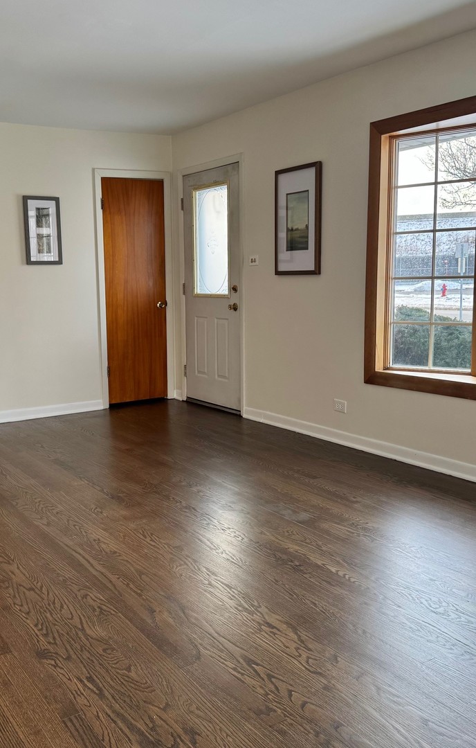 3051 South Scott Street Des Plaines, IL 60018 - Photo 3 of 43 a view of an empty room with wooden floor and a window