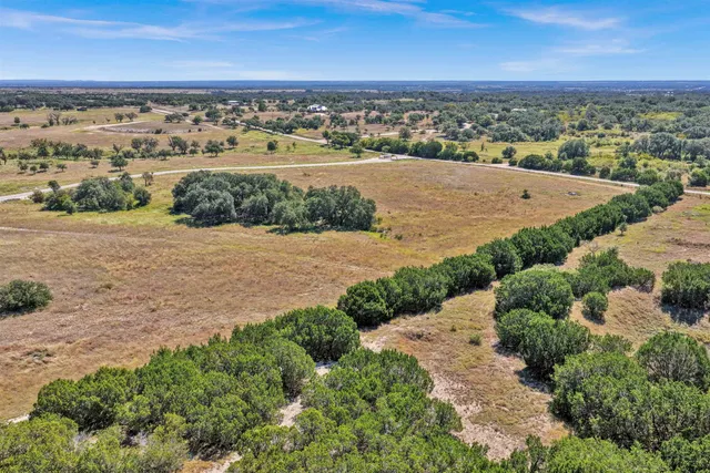 an aerial view of ocean and residential houses with outdoor space