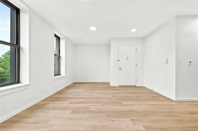 a view of a kitchen with white cabinets and wooden floor