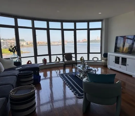a living room with furniture and floor to ceiling windows