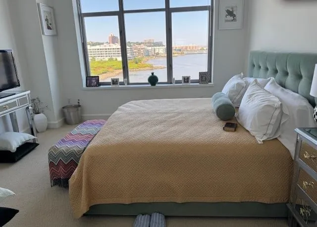 a bedroom with a bed and next to a window