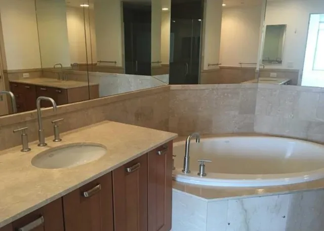 a bathroom with a tub sink and mirror