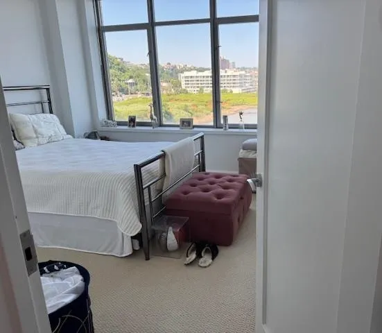 a bedroom with a bed and large window