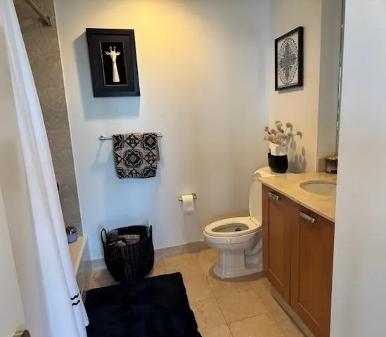 a bathroom with a toilet and a shower curtain