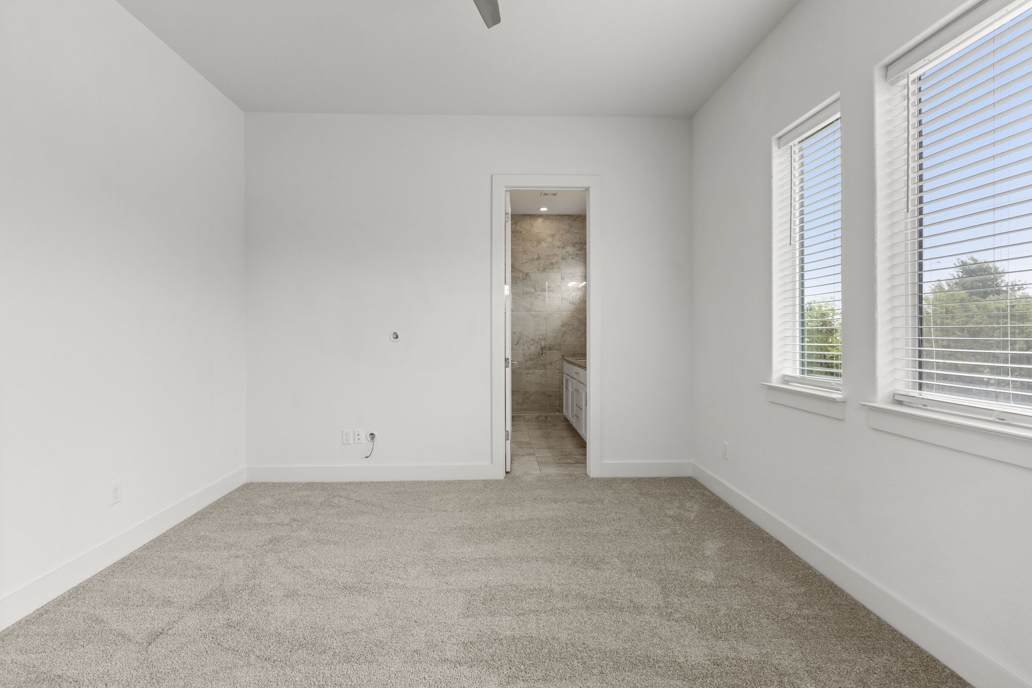 2050 Lohmans Spur Road, Unit 2005 Lakeway, TX 78734 - Photo 8 of 36 2050 Lohmans Spur #2005 - the primary bedroom is on the main floor with high ceilings, large windows, a full bathroom with walk-in shower, and walk-in closet.