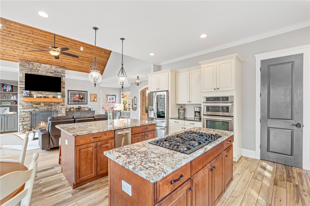 827 Top Ridge Drive Sunset, SC 29685 - Photo 13 of 44 This open concept kitchen and living area features a gas cooktop, double oven, and wood flooring.
