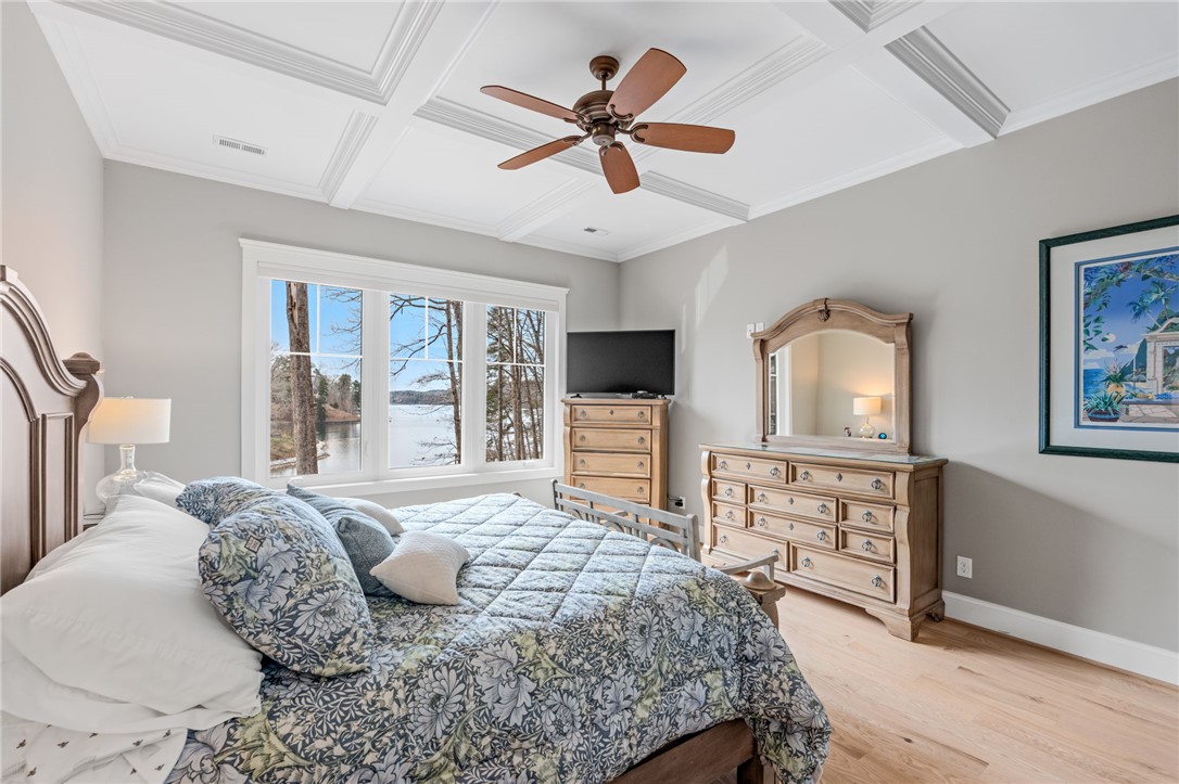 827 Top Ridge Drive Sunset, SC 29685 - Photo 19 of 44 This tranquil bedroom offers panoramic lake views, elegant coffered ceilings, and rich hardwood flooring.