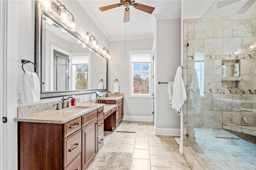 827 Top Ridge Drive Sunset, SC 29685 - Photo 20 of 44 This bathroom features elegant vanities, a spacious shower, and bright window views.