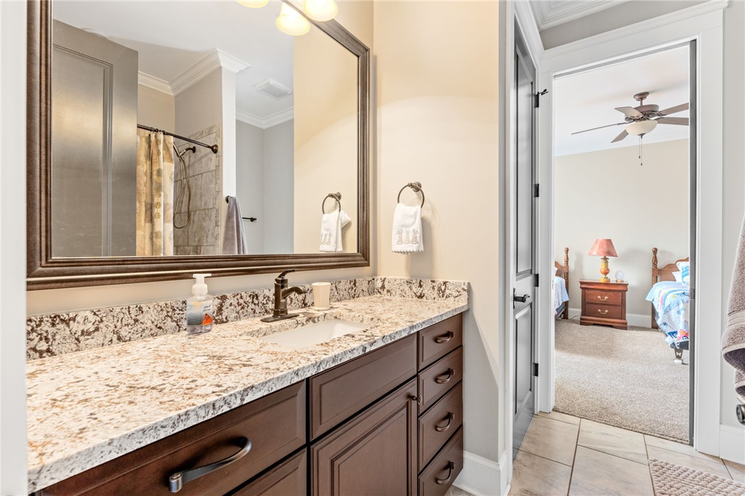 827 Top Ridge Drive Sunset, SC 29685 - Photo 28 of 44 This bathroom features elegant granite countertops, a spacious vanity, and easy access to an adjacent bedroom with shower/tub.