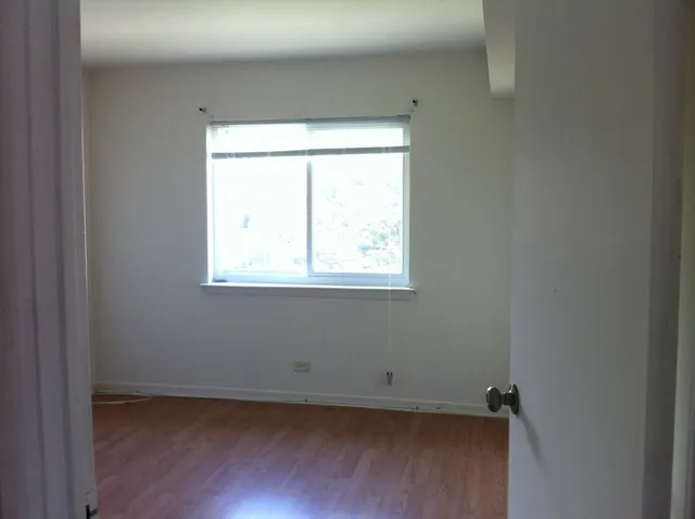 a view of a small space with wooden floor and a window