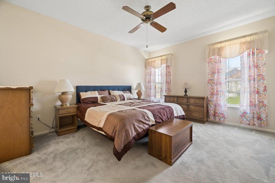 84 Chain Boulevard Bayville, NJ 08721 - Photo 21 of 39 a bedroom with a bed and a chandelier