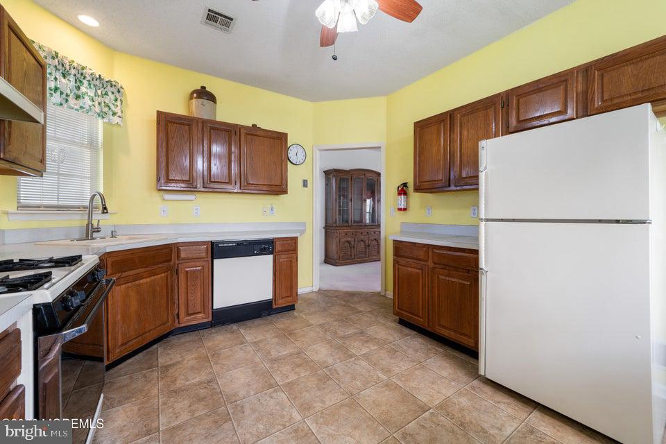 84 Chain Boulevard Bayville, NJ 08721 - Photo 8 of 39 a kitchen with stainless steel appliances granite countertop a refrigerator a stove a sink a microwave a dining table and chairs with wooden floor