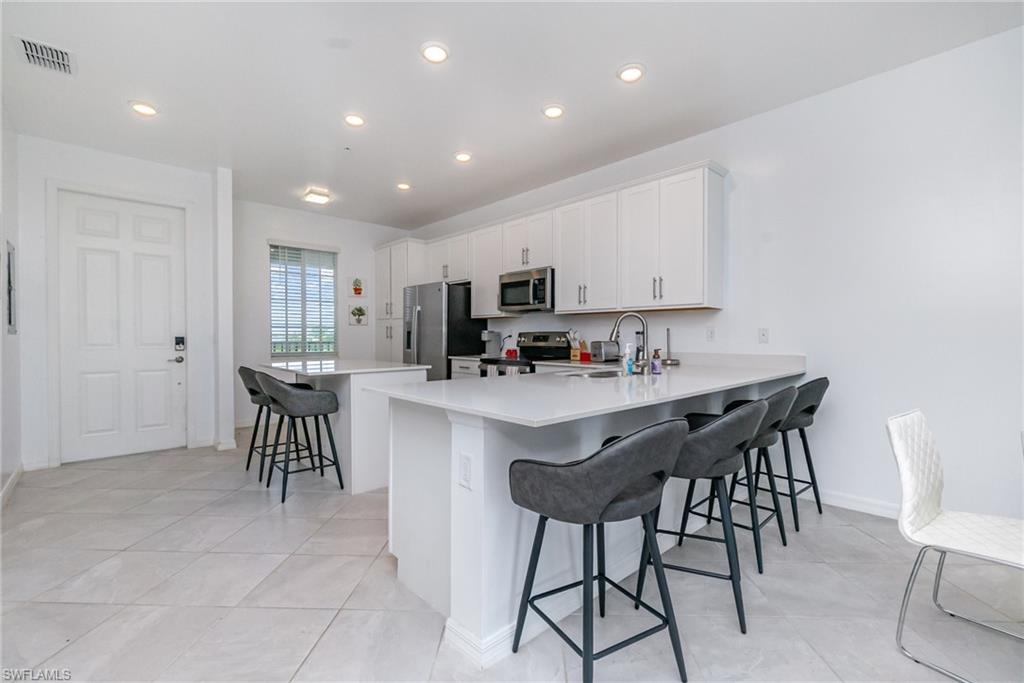 43989 Boardwalk Loop, Unit 2043 Babcock Ranch, FL 33982 - Photo 11 of 45 a kitchen with kitchen island granite countertop wooden cabinets and stainless steel appliances