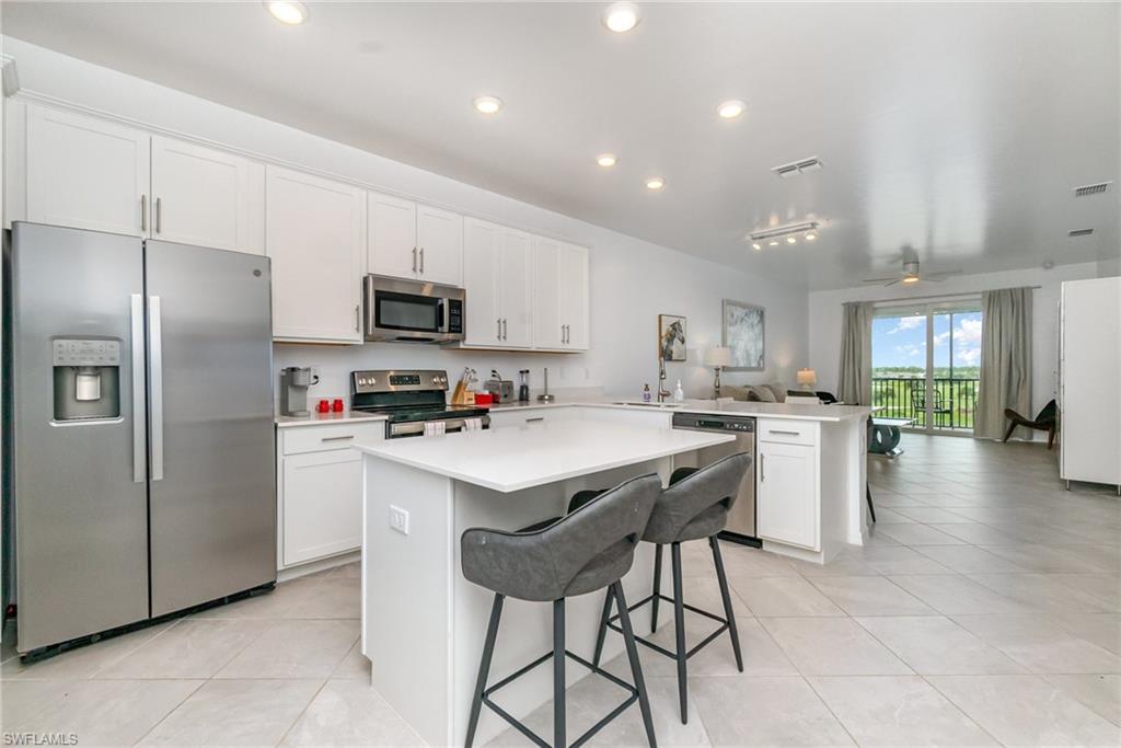 43989 Boardwalk Loop, Unit 2043 Babcock Ranch, FL 33982 - Photo 12 of 45 a kitchen with kitchen island a refrigerator stove and microwave