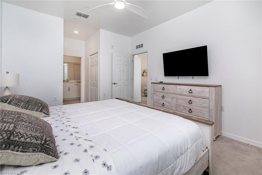 43989 Boardwalk Loop, Unit 2043 Babcock Ranch, FL 33982 - Photo 18 of 45 a bedroom with a bed and a flat screen tv