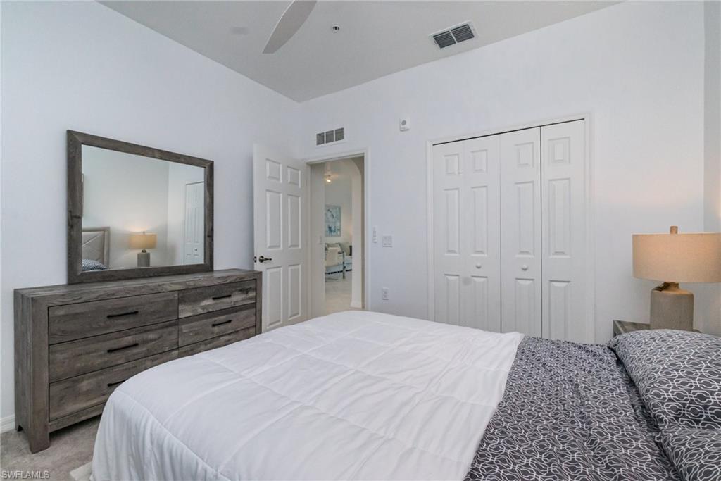 43989 Boardwalk Loop, Unit 2043 Babcock Ranch, FL 33982 - Photo 24 of 45 a bedroom with a bed and a mirror on dresser