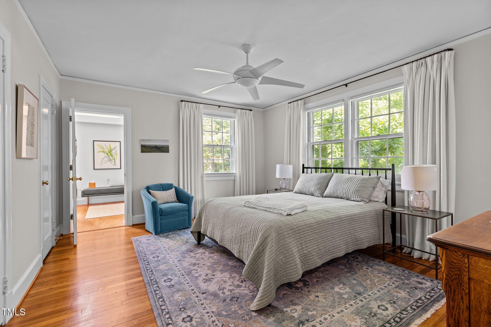 2706 Stuart Drive Durham, NC 27707 - Photo 13 of 26 a bedroom with a large bed a chandelier and windows