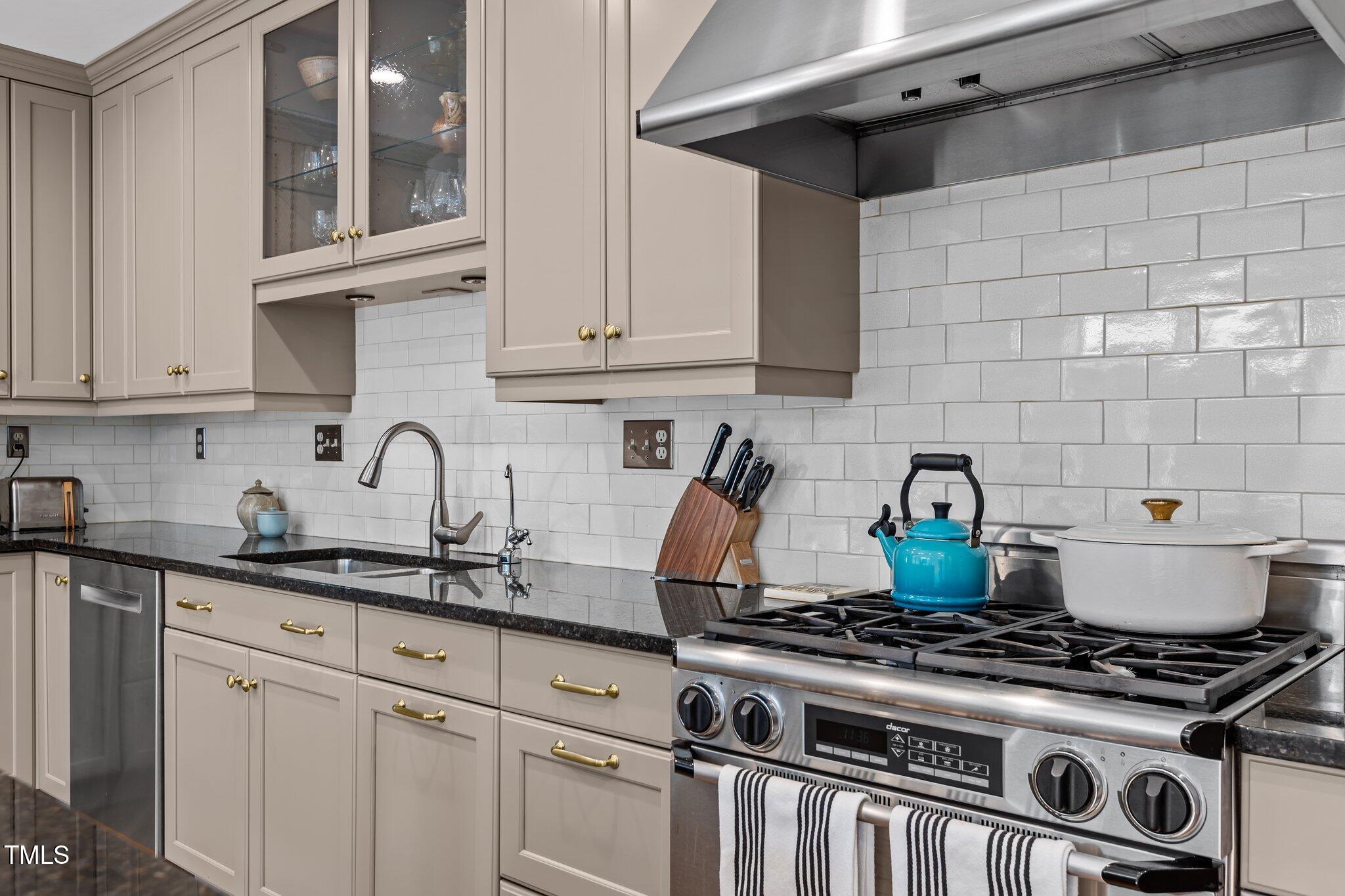2706 Stuart Drive Durham, NC 27707 - Photo 9 of 26 a kitchen with granite countertop a stove and a sink