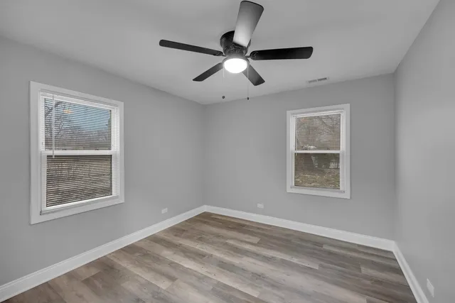 a view of a hallway with wooden floor and closet
