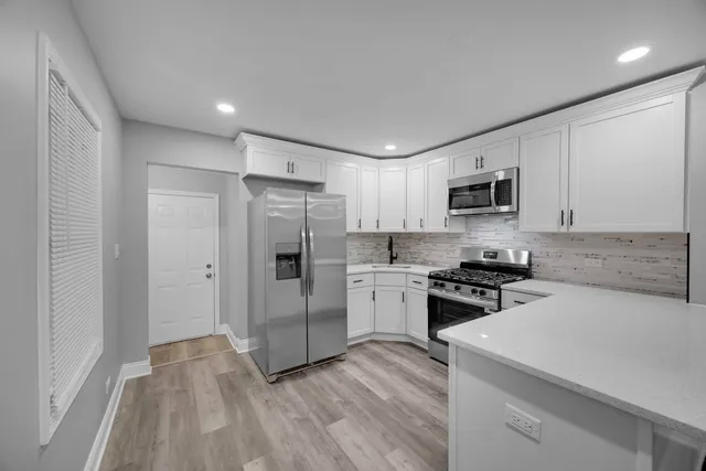 a kitchen with cabinets stainless steel appliances and a counter space