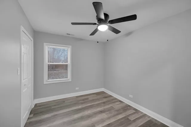 a view of empty room with wooden floor