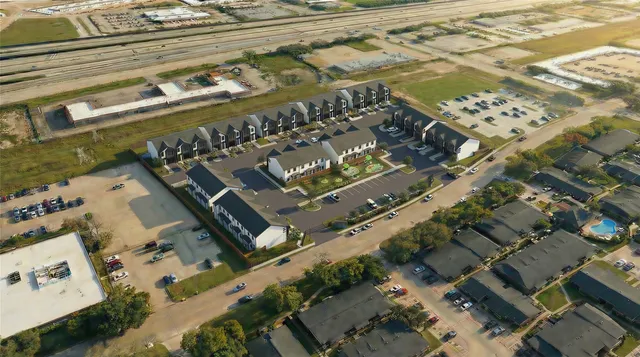 an aerial view of a residential building with parking