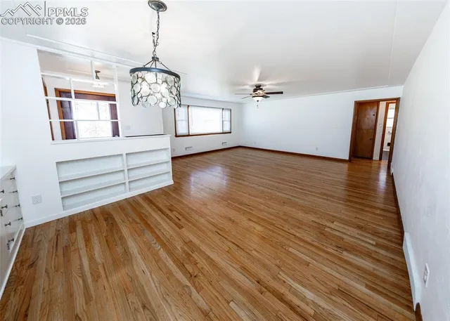 a view of empty room with wooden floor