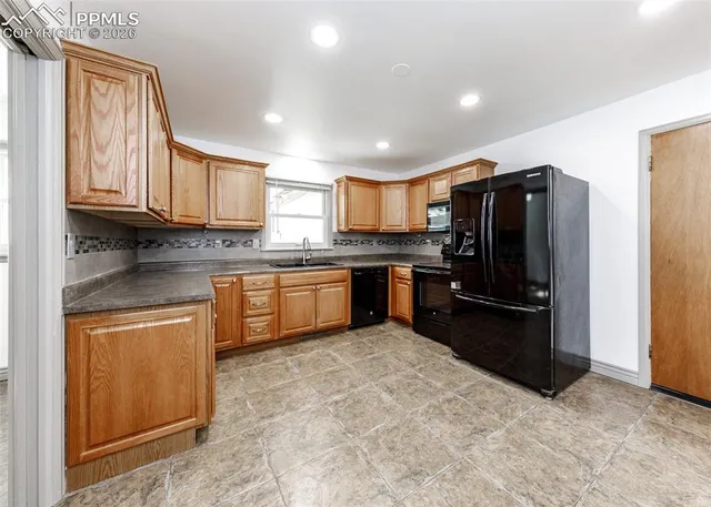 a kitchen with stainless steel appliances granite countertop a refrigerator stove top oven and sink