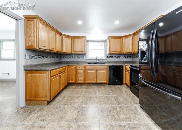 a large kitchen with stainless steel appliances granite countertop a stove sink and cabinets