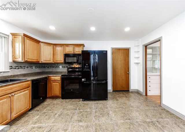 a kitchen with stainless steel appliances granite countertop a refrigerator and a stove top oven