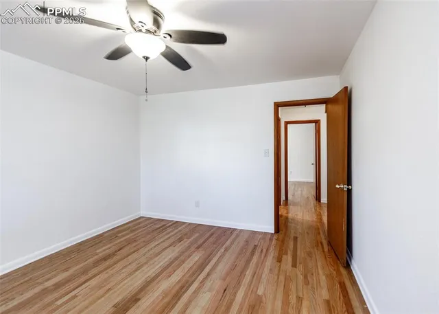 a view of empty room with wooden floor