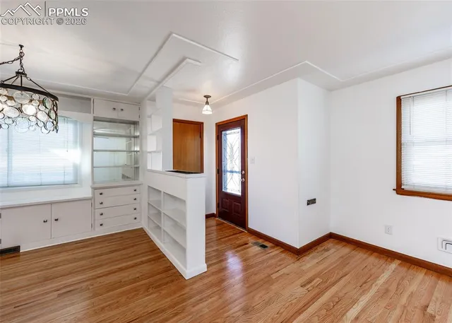 a view of empty room with wooden floor