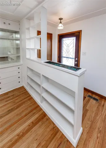 a view of a room with wooden floor and fan