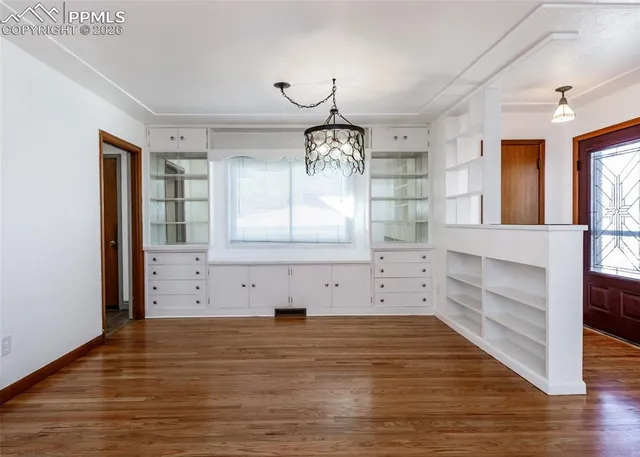 a view of empty room with wooden floor and window
