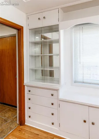 a view of an empty room with cabinet and window
