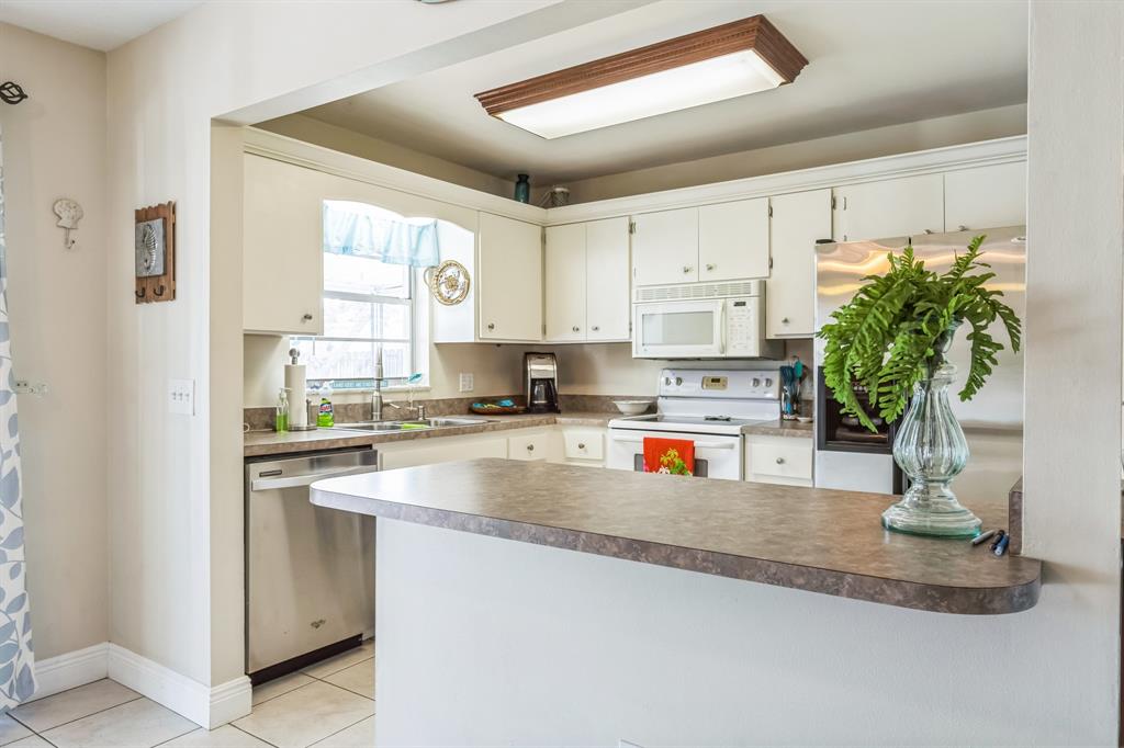 1153 Southeast Dolphin Drive Stuart, FL 34996 - Photo 11 of 31 a kitchen with stainless steel appliances granite countertop a sink a stove and a window