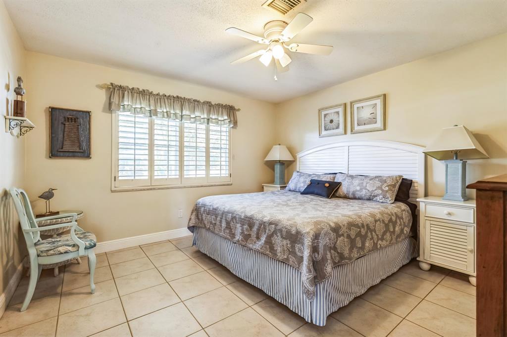 1153 Southeast Dolphin Drive Stuart, FL 34996 - Photo 14 of 31 a bedroom with a bed and a table